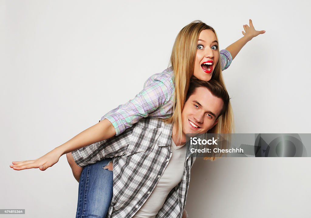 young man carrying girlfriend on his back. love, family and people concept:   lovely couple,  young man carrying girlfriend on his back. 2015 Stock Photo