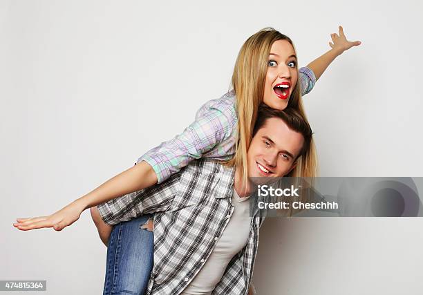 Young Man Carrying Girlfriend On His Back Stock Photo - Download Image Now - 2015, Activity, Adult