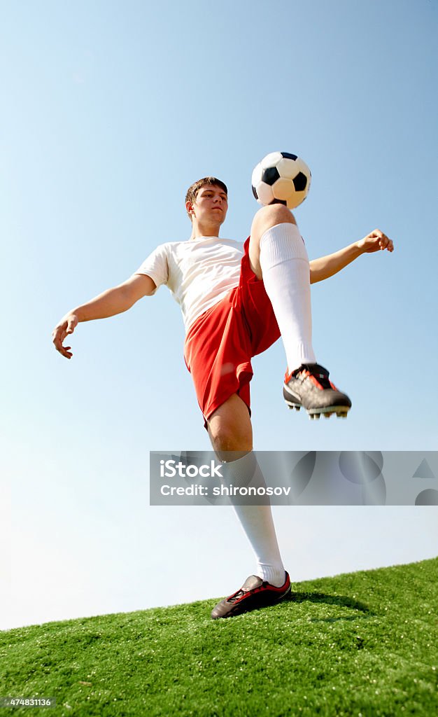 Active game Portrait of soccer player kicking ball by knee on football field  2015 Stock Photo