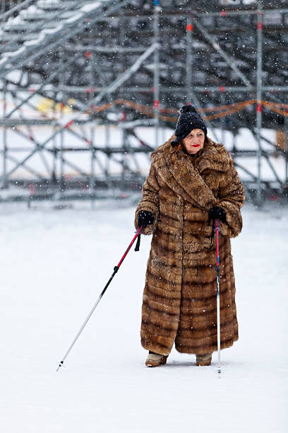 Woman in Furcoat in front of Spectator Stands stock photo