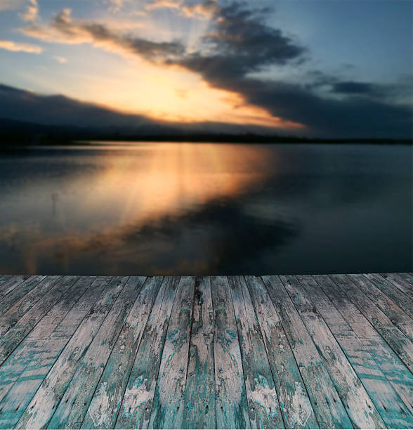 Empty wooden platform beside tropical sea with sunrise