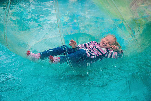 Child in the ball on water The little cheerful girl swims in a sphere on water zorbing stock pictures, royalty-free photos & images