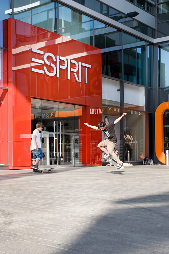 Mainz, Germany - September 25, 2011: A teenager on a skateboard performing some nice stunts in front of the huge entrance of a Esprit fashion shop in the city center of Mainz, Germany.