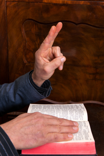 Oath on the Holy Bible against the dark furniture