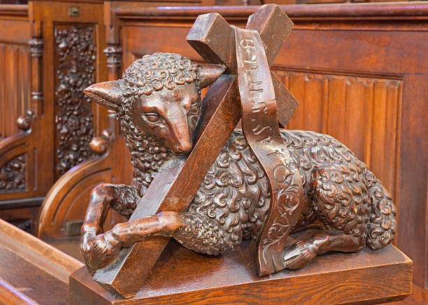 Bratislava - Agnus Dei carved sculpture from presbytery of cathedral Bratislava - Agnus Dei carved sculpture from bench in presbytery in st. Matins cathedral from years 1863 – 1878 from manufactures of Anton Fürst a Johann Hutterer. agnus dei stock pictures, royalty-free photos & images