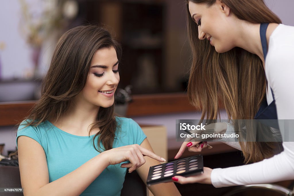 Woman with makeup artist choosing color of eyeshadow Advice Stock Photo