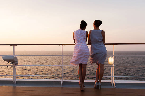 two women looking at sunrise on cruise ship