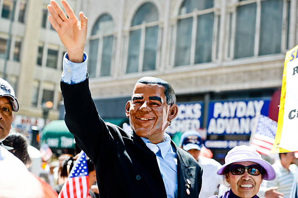 Los Angeles, USA - May 1, 2013: May Day March in Los Angeles Downtown, USA. People holding banners representing different social structures, organizations. March was mostly dedicated to Immigration reform discussed. Obama Puppet waving hand, walking in the crowd.