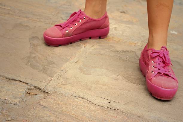 istock Pink shoes on a brown background at the park. 474858180