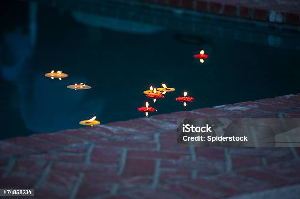 Votive Candles Floating In Swimming Pool Stock Photo - Download Image Now - 2015, Blue, Candle