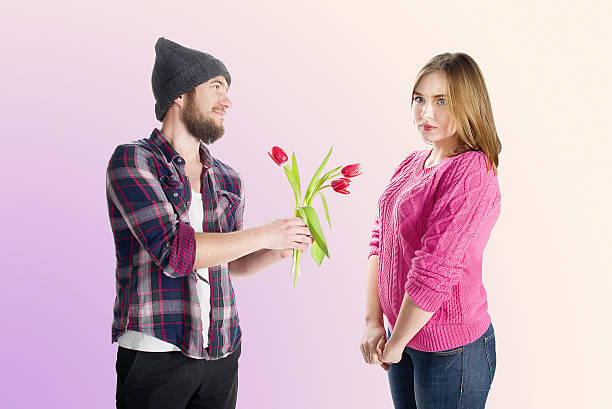istock young man giving red tulips  girl 474858278