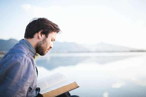 istock Portrait of young man reading a book 474859104