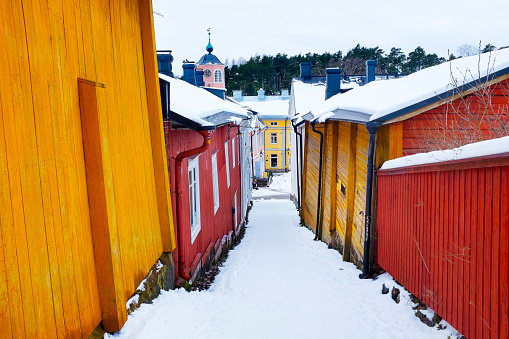 Snowy alley leading to the Raatihuoneentori Square in the colourful wooden Old City of Porvoo.