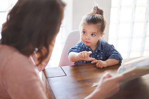 Cute girl with mom reading a book