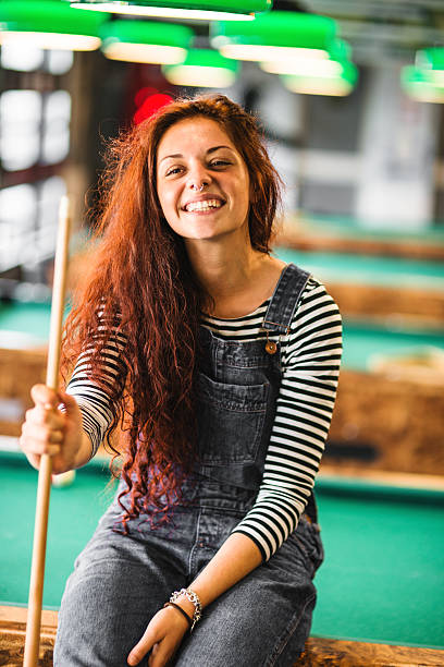 Happiness girl standing in a pub at the pool table