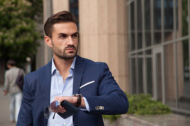 istock Business man standing on the city checkin the time 474868764