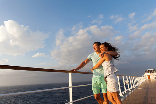 loving married couple standing on cruise deck enjoying sunset together