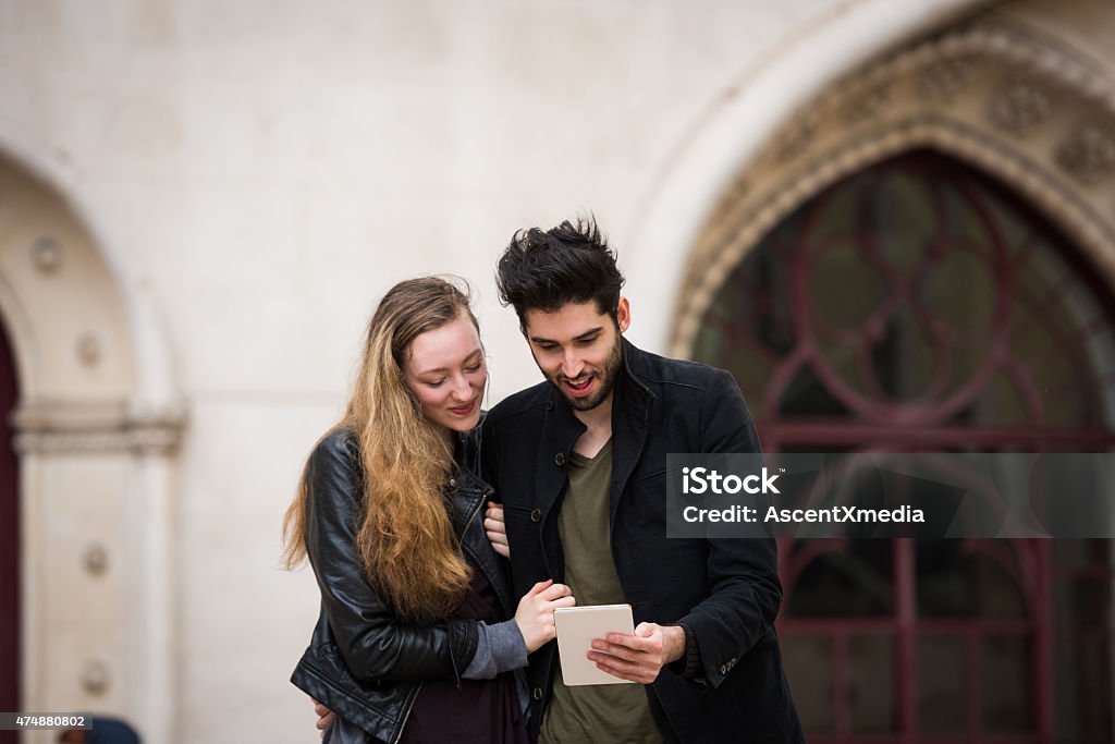 Couple using a tablet on vacation Tourist couple using a digital tablet on vacation 20-29 Years Stock Photo