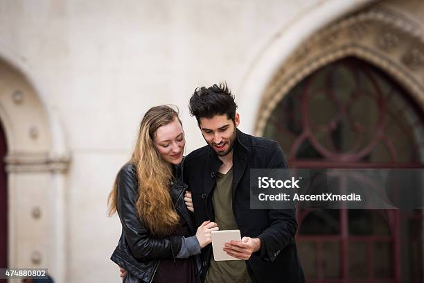 Couple Using A Tablet On Vacation Stock Photo - Download Image Now - 20-29 Years, 2015, 30-39 Years