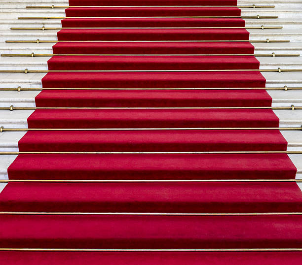 istock Red carpet on white marble stairs 474888126