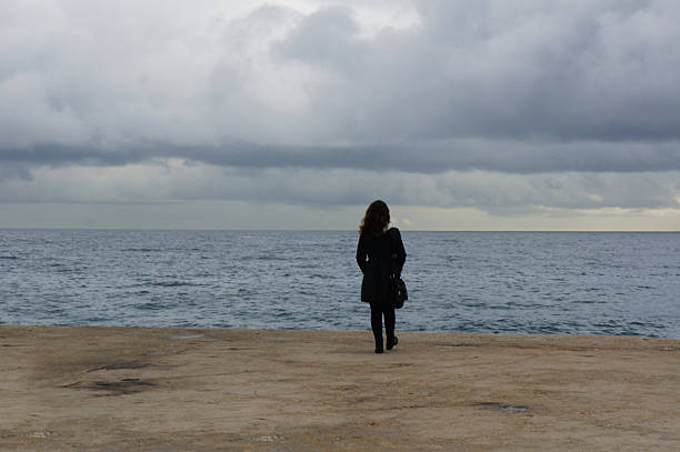 istock girl walking to the sea 474888695