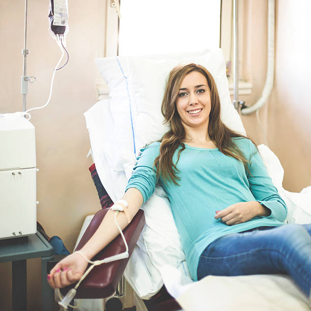 Donating blood Attractive female giving a blood donation. About 20 years old Caucasian female, in casual clothing. blood bank stock pictures, royalty-free photos & images