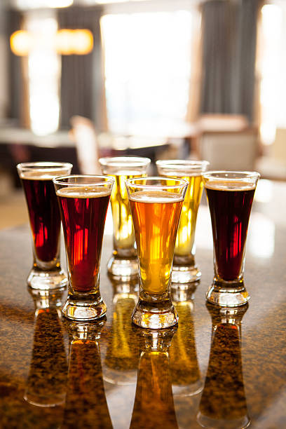 istock Five glasses of beer samples sitting on a bar. 474894704