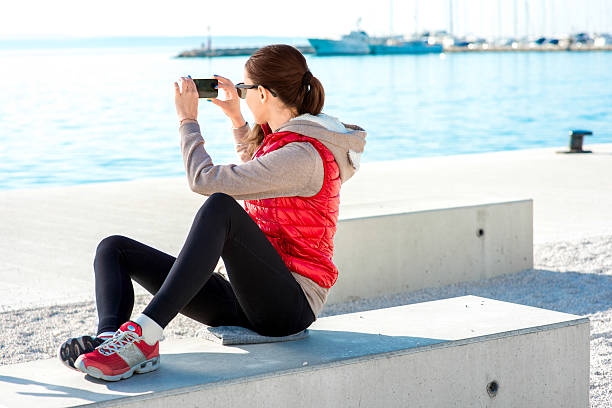 sport frau auf die promenade - women sweater vest beach pier stock-fotos und bilder