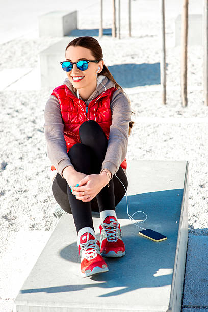 sport frau auf die promenade - women sweater vest beach pier stock-fotos und bilder