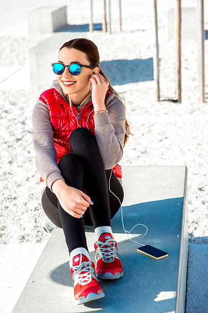 sport frau auf die promenade - women sweater vest beach pier stock-fotos und bilder