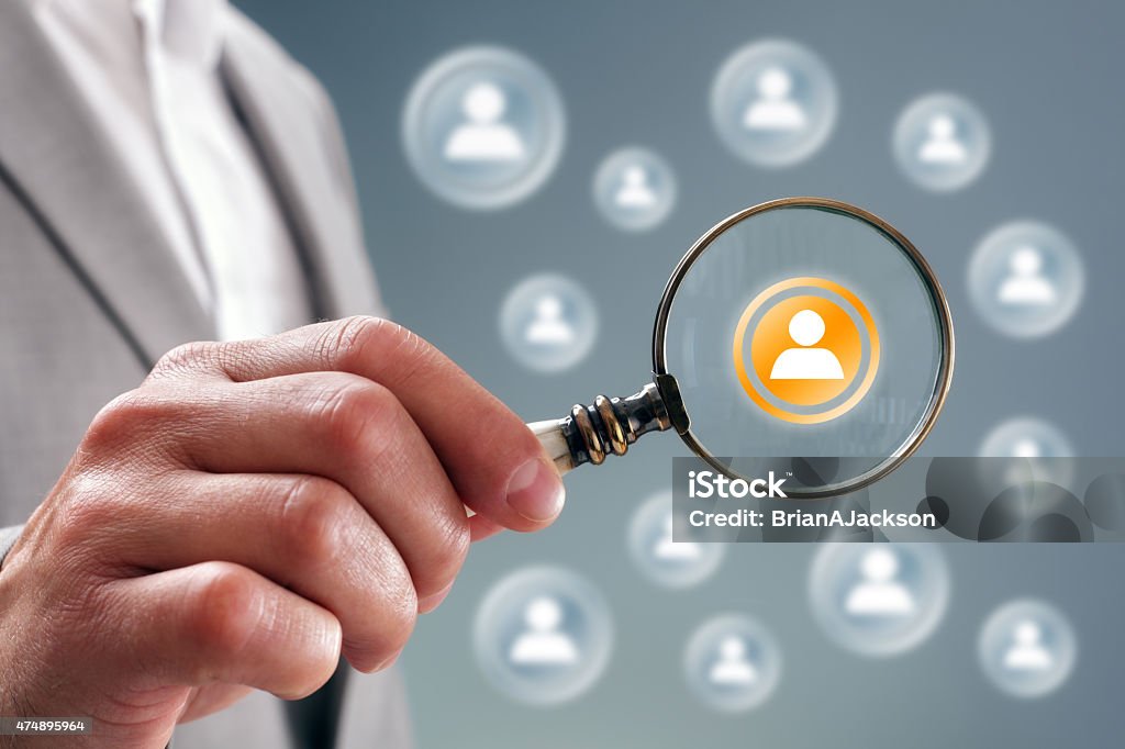 Search for team personnel or contacts Businessman with magnifying glass on team personnel or contact icon concept for recruitment, social media, network, community and  internet marketing Magnifying Glass Stock Photo