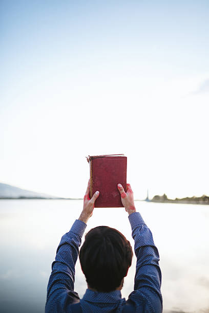 istock Young man holding book and looking away 474896058
