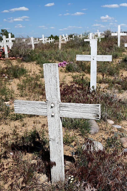 istock Worn white wood cross in a forgotten graveyard with weeds 474903878