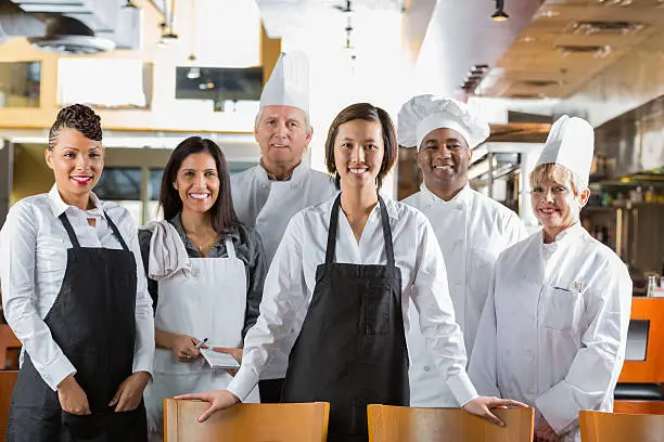 Photo of Diverse staff of chefs and waiters in modern restaurant kitchen