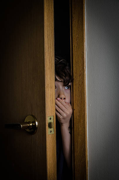 istock Boy peeking through closet door with fear 474906406