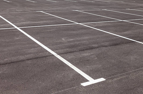 istock White traffic markings on a gray asphalt parking lot 474906812