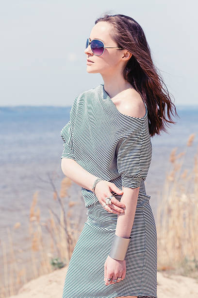 istock Beautiful model in striped dress posing at summer beach 474910814