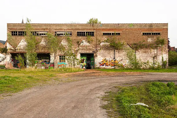 Photo of abandoned factory building with graffiti on the wall