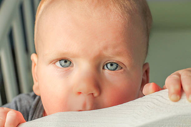 istock Baby boy sitting in his bed, smiling, closeup 474912102