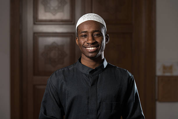 Portrait Of A Black African Man In Mosque African Muslim Man Making Traditional Prayer To God While Wearing A Traditional Cap Dishdasha middle eastern culture photos stock pictures, royalty-free photos & images