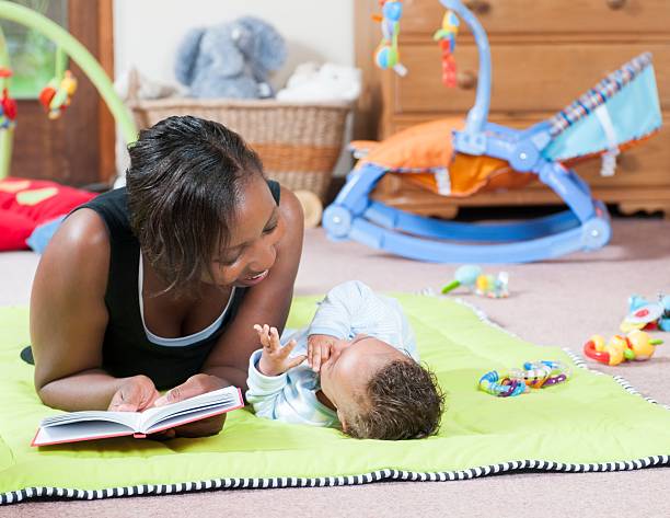 storytime sulla playmat con accompagnatore e baby - baby1 foto e immagini stock