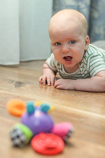 istock Baby boy lying on the floor, grab a toy 474917534