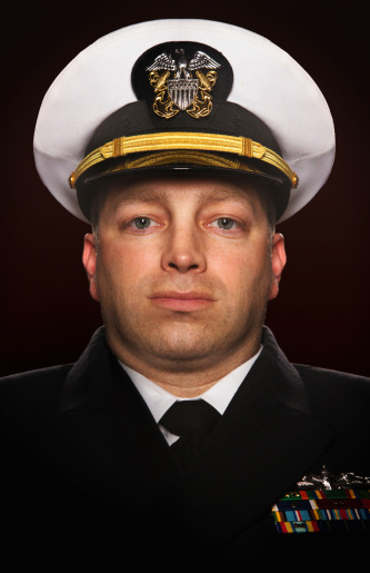 American military officer portrait on dark background. He has a somewhat sad expression.
