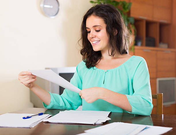 istock Happy brunette woman reading document 474923942
