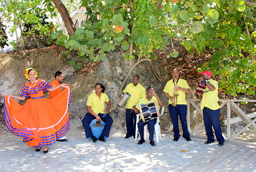 Cayo Levantado, Dominican Republic-April 9, 2009:  A colorful dancer and musicians welcome tourists to the resort island of Cayo Levantado the Dominican Republic with their traditional music.