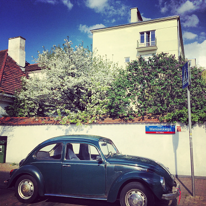 Warsaw, Poland - April 27, 2015: Old car parked on a street full of private houses in Warsaw, Poland