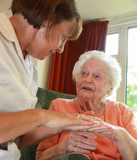 istock Care worker nurse caring for an elderly womans personal needs 474935734