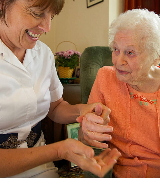 istock Care worker nurse caring for an elderly womans nails. 474936802