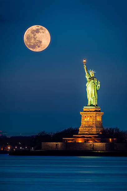 statua della libertà e una crescente superluna - crown liberty statue foto e immagini stock