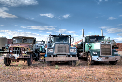 Junkyard with three trucks standing in the foreground